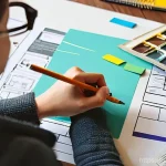 인테리어 코디네이터 자격증 시험 후기 - **Prompt:** A young adult interior design student, casually dressed, is deeply focused in a sunlit h...